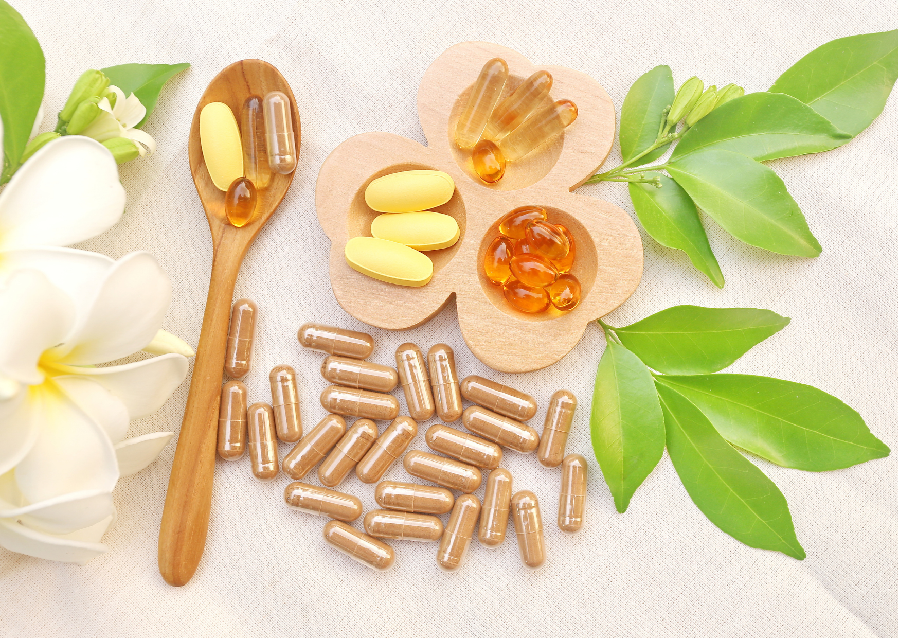 How to Boost Your Immune System Quickly various supplement pills displayed on wooden plate and spoon