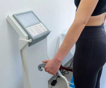 Woman standing on body composition scale holding handles
