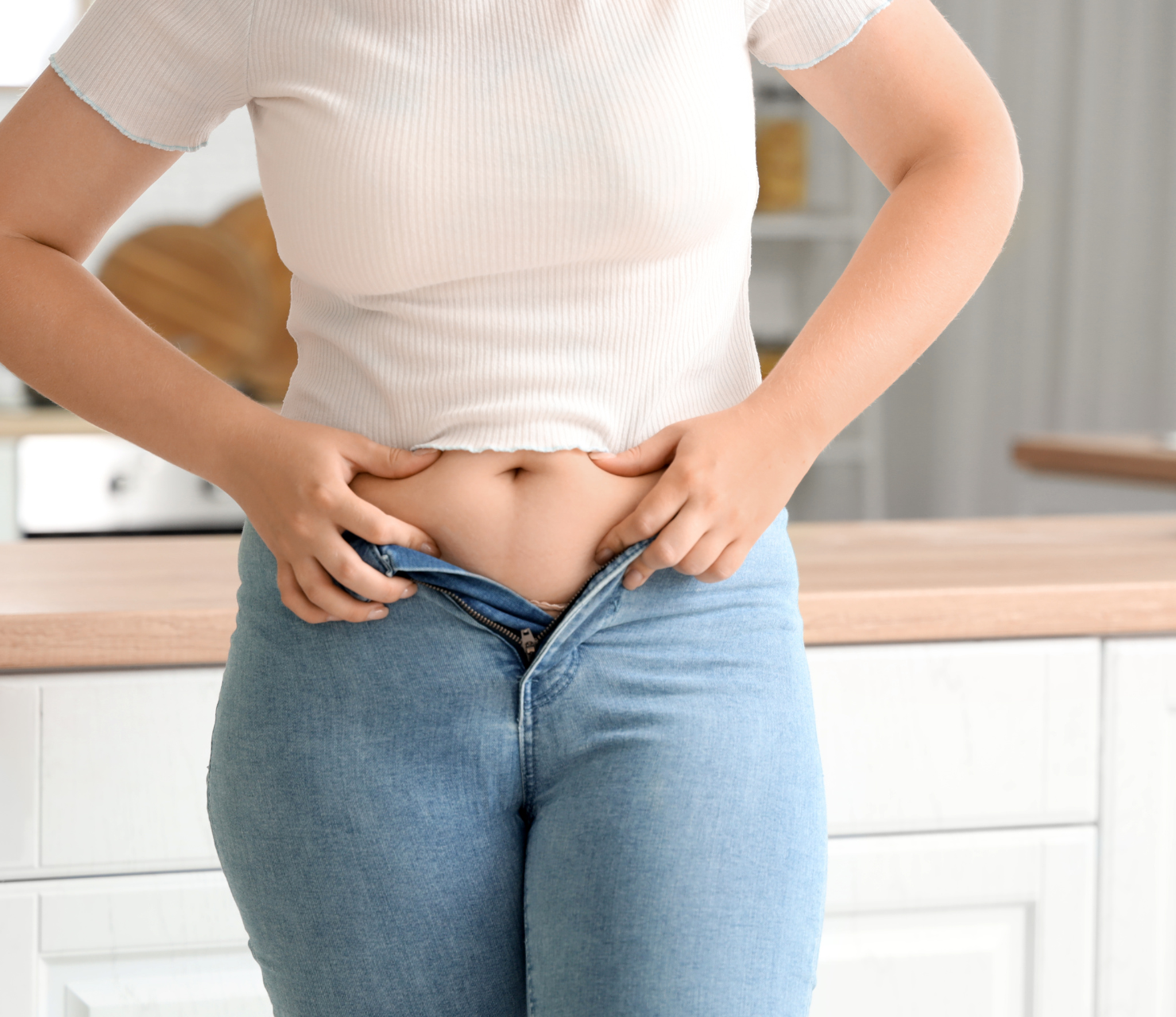 post pregnancy weight gain female struggling to close her pants